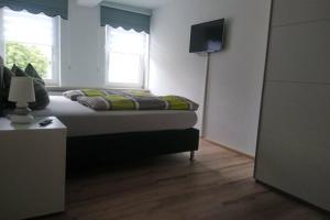 um quarto com uma cama e uma televisão na parede em Kastanienblick em Sankt Andreasberg