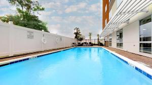 a large blue swimming pool next to a building at Holiday Inn Express & Suites - Chalmette - New Orleans S, an IHG Hotel in Chalmette