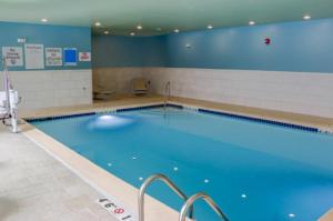 une grande piscine avec de l'eau bleue dans l'établissement Holiday Inn Express & Suites - Detroit North - Roseville by IHG, à Roseville