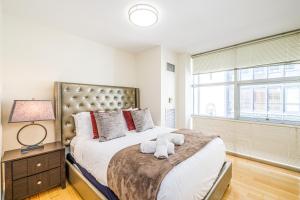 سرير أو أسرّة في غرفة في Evonify Stays - Theatre District Apartments