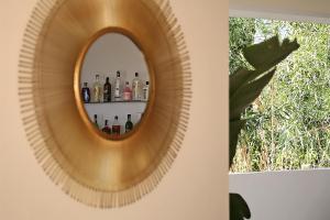 a mirror on a wall with bottles on a shelf at Casa Bodhi Boutique Hotel & Spa in Marbella