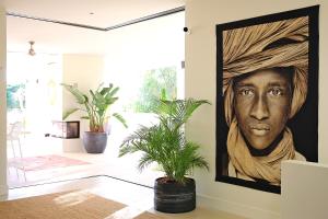 a portrait of a man on a wall with a plant at Casa Bodhi Boutique Hotel & Spa in Marbella
