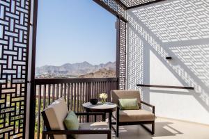 een balkon met 2 stoelen en een tafel met uitzicht bij InterContinental Fujairah Resort, an IHG Hotel in Al Aqah