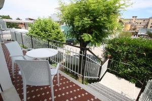 a balcony with a table and chairs and a tree at Villa Ca'Bianca in Bibione