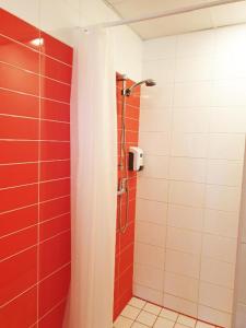 a bathroom with a shower with red and white tiles at Mereranna apartment 5 in Kuressaare