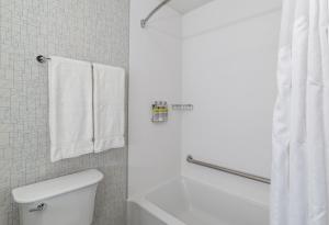 a bathroom with a toilet and a shower with towels at Holiday Inn Express & Suites - Saskatoon East - University, an IHG Hotel in Saskatoon