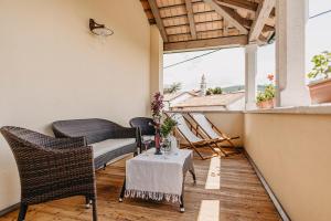 a balcony with chairs and a table and a window at Casa Krasna Gourmet Boutique Hotel in Lokev