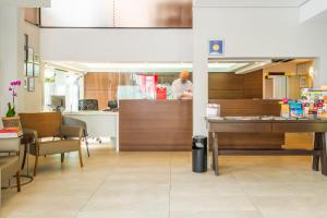 a restaurant with a counter and a person in the kitchen at Hotel Melo in Balneário Camboriú