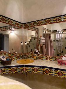 baño con lavabo y espejo grande en La Casona Azul Boutique Hotel, en Malinalco