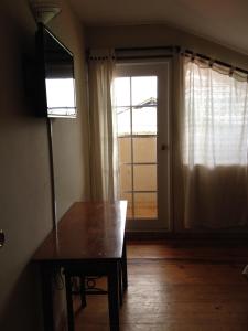 a room with a table and a door with a window at Hotel Posada Los Delfines in Bocas Town