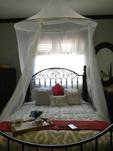 ein Schlafzimmer mit einem Himmelbett und einem Tisch darauf in der Unterkunft Heavenly Suite in Little Havana Free Parking - 1S in Miami
