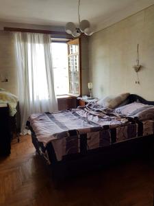 1 cama grande en un dormitorio con ventana en Hostel Levan, en Tiflis