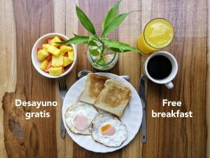 a breakfast plate with eggs and toast and a cup of coffee at Bona Vida Hostel in Ríohacha