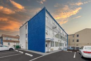 a blue building with cars parked in a parking lot at AIRE Hotel North Beach Jersey Shore in Seaside Heights