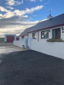 a white house with a driveway in front of it at Littles Cottage, heart of the Mournes in Annalong