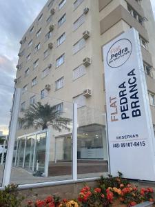 un edificio de hotel con un cartel delante en Flat Pedra Branca, en Palhoça