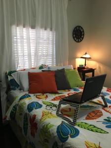 a bedroom with a bed with a laptop on it at The Jewel of Little Havana - 2S in Miami