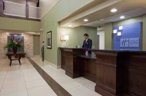 a man standing at a bar in a hospital lobby at Holiday Inn Express & Suites Madison-Verona by IHG in Verona +40 photos
