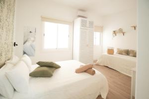 a white room with two beds and a window at Parigi Hotel bed and Breakfast in Santa Cruz de Tenerife