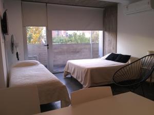 a room with two beds and a sliding glass door at Pueyrredon 1101 in Rosario