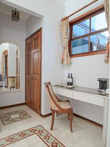 uma casa de banho com uma secretária, uma cadeira e um espelho. em Fleur de Lys em San José