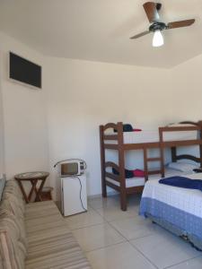 a bedroom with two bunk beds and a couch at Vô Pedrinho in Olímpia