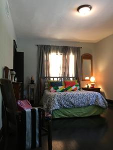 - une chambre avec un lit doté d'oreillers colorés et d'une fenêtre dans l'établissement Private room in the Heart of Little Havana, à Miami