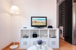 ein weißes Entertainment-Center mit einem TV darüber in der Unterkunft Flatguest Triana in Las Palmas de Gran Canaria