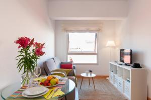 Flatguest Triana في لاس بالماس دي غران كاناريا: غرفة معيشة مع طاولة مع وعاء من الفواكه