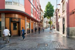 a group of people walking down a city street at Triana in Triana