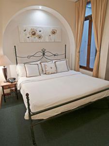 a bedroom with a large bed with white sheets at Fleur de Lys in San José