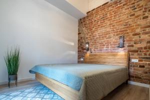 a bedroom with a brick wall and a bed at Klaipeda Old Town Unique in Klaipėda