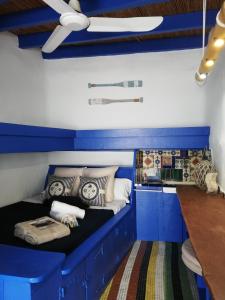 Habitación azul y blanca con cama con almohadas en Casa El Grial, en Peñíscola