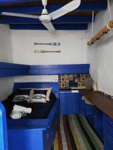 Habitación azul con cama y ventilador de techo. en Casa El Grial, en Peñíscola 60 fotos más