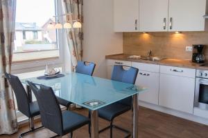 a kitchen with a glass dining table and chairs at Haus-Meeresglueck-Seemuschel in Dahme