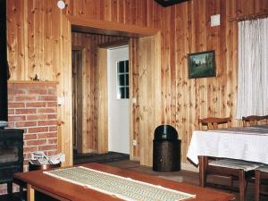 a room with wooden walls and a bed and a fireplace at 4 person holiday home in TORSBY in Mårbacken