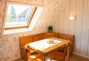 a wooden table and chairs in a room with a window at Haus-Wiwibarg-OG in Dahme