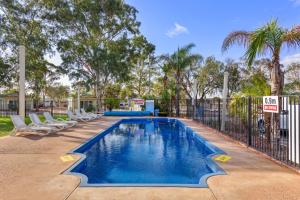 a swimming pool with chairs and a fence at Discovery Parks - Port Augusta in Port Augusta