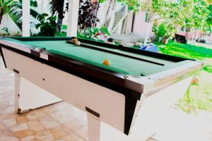 a pool table with a green top on a patio at Sitio Raio De Sol in Cabo Frio