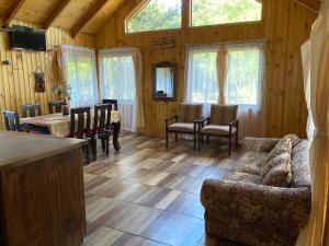 a living room with a couch and a table and chairs at Camping y Cabañas Playa Caliboro in Los Ángeles