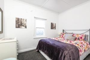 een slaapkamer met een bed en een raam bij Croft Cottage in Hepburn Springs