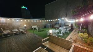 a patio with tables and chairs and lights at night at Hotel Iam in Suncheon