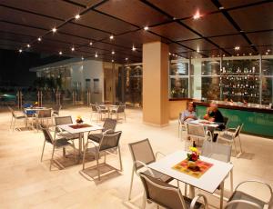 two people sitting at tables in a restaurant at Estelar Apartamentos Barranquilla in Barranquilla