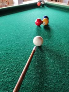 two billiard balls and a cue on a pool table at Hotel Chimborazo Internacional in Riobamba