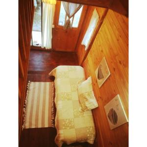 a bedroom with a bed in a wooden room at El Canto de la Ballena Bungalow 2 niveles in Puerto Pirámides
