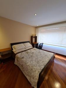 Un dormitorio con dos camas y una ventana. en Tu Hogar cerca a la zona T, en Bogotá