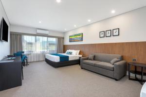VineyardGateway Motel的配有床和沙发的酒店房间