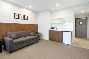 a living room with a couch and a kitchen at Gateway Motel in Vineyard