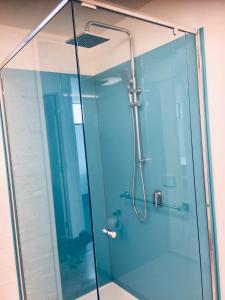 a shower with a glass door in a bathroom at Max's Beachside Holiday Home in Torquay