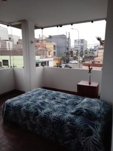 a bedroom with a bed and a large window at Sucesac in Lima